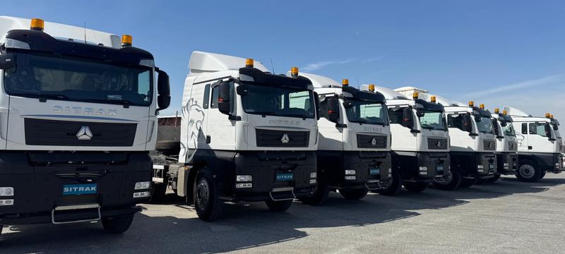 Line of white SITRAK truck heads in the company yard